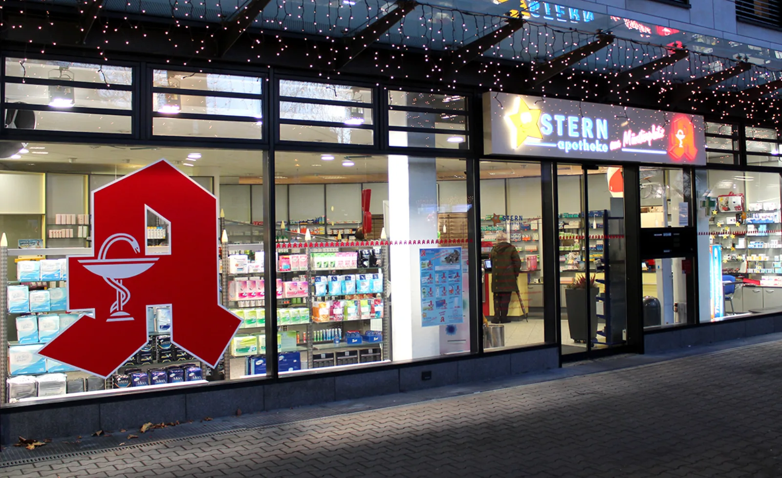 Die Stern-Apotheke am Münsterplatz am Abend, beleuchtete Schaufenster
